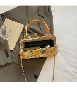 Detail of bamboo handle and floral bear embroidery on vintage style shoulder bag