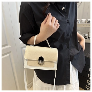 Detail of beige woven square bag with white leather trim and a silver metallic lock