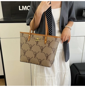 Detail shot of a large tote bag with LOVE print and golden kangaroo logo on model