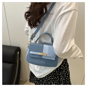 Chic blue patchwork crossbody bag detail shown on model with floral skirt
