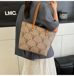 Close-up of a large tote bag with OYE monogram print and golden kangaroo logo