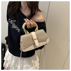 Detail der eleganten cremefarbenen Lederhandtasche mit Paillettenklappe und U-Metallgriff