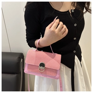 Detail of pink patchwork crossbody bag featuring tweed flap and circular metal twist lock