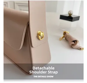Detail of premium beige leather handbag featuring a gold metal buckle and detachable strap