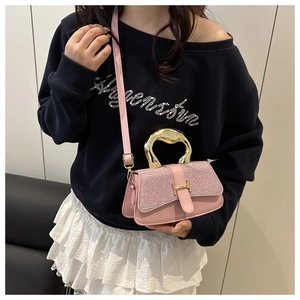 Detail of pink crossbody bag with glitter flap, gold metal handle and H-shaped buckle
