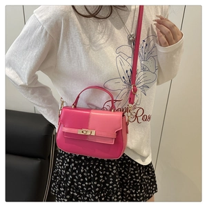 Detail of two-tone pink crossbody bag with gold twist lock on floral dress outfit