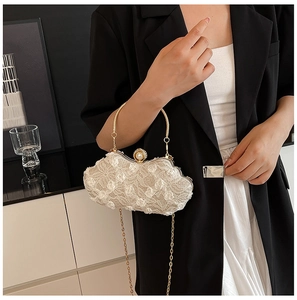 Detailed shot of lace floral evening bag with pearl clasp and gold circular handle