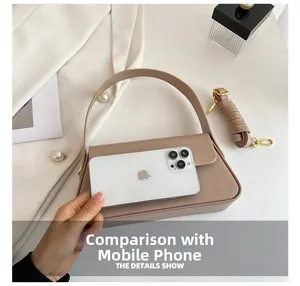 Detailed comparison of earth-tone leather handbag size with a smartphone and adjustable strap