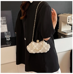 Detailed shot of floral lace evening bag with large pearl clasp and golden chain strap