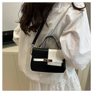 Rear view of two-tone black and white leather Kelly bag worn on white shirt