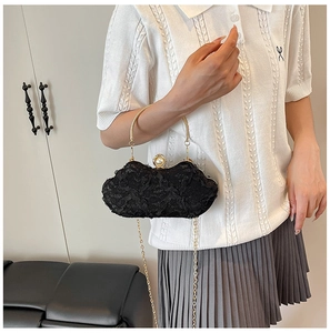 Detail of black floral lace clutch bag with vintage gold handle and pearl clasp