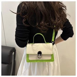 Detail of contrast color crossbody bag with green leather trim and silver metal lock