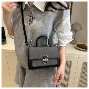 Detail of trendy contrast crossbody bag with gray twill fabric and silver oval lock