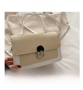 Detail of color-block crossbody bag featuring woven texture and silver metal twist lock