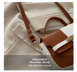 Detail of adjustable leather shoulder strap with golden metal buckle on bicolor handbag