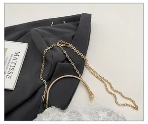 Detail view of lace floral evening bag with golden ring handle and detachable chain strap