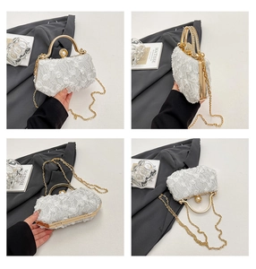 Detail of white lace evening clutch bag with gold frame and decorative pearl clasp