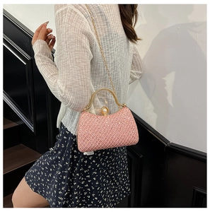 Detail of pink rhinestone evening bag with gold circular handle and pearly clasp closure
