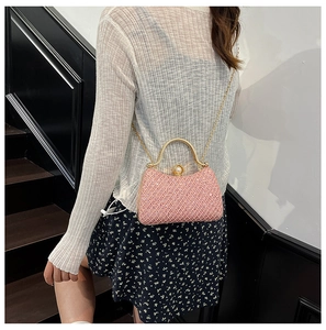 Detailed view of pink quilted clutch bag with rhinestone finish and chain strap