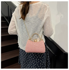 Pink glitter evening bag featuring a gold handle, pearl clasp and chain strap detail