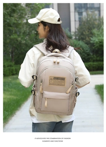Side view of a large capacity beige travel backpack with multi-pocket design on a model