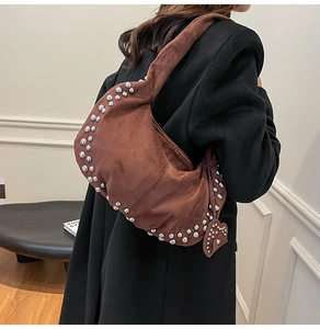 Détails des rivets argentés et texture daim rétro sur le sac hobo en forme de croissant