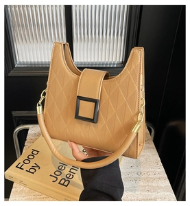 Detail of camel quilted bucket bag featuring lychee grain leather and gold chain strap