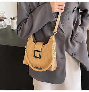 Detail of khaki tote bag with geometric quilted pattern and square black buckle clasp