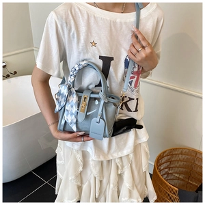Détail d'un sac gelée bleu clair transparent avec foulard en soie et fermoir doré