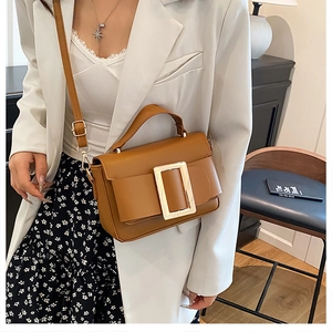 Detail of vintage brown leather handbag featuring a large golden metallic square buckle