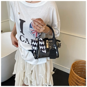 Détail du sac seau en PVC transparent avec bordure en cuir et foulard à damier chic