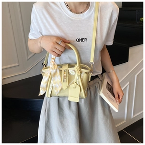 Détail du sac seau transparent jaune en PVC avec foulard en soie et anse en cuir
