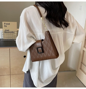 Brown quilted leather shoulder bag with gold chain strap shown on a model side view