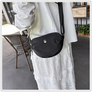 Detailed view of black nylon crescent crossbody bag featuring an adjustable shoulder strap