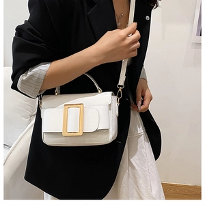 Close-up of white crossbody bag featuring a rectangle gold buckle and smooth faux leather