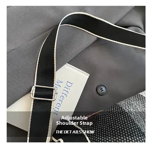 Gros plan sur la bandoulière en toile rayée ajustable avec boucle argentée