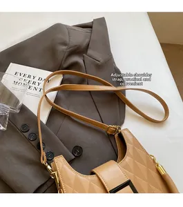 Detail of adjustable strap and buckle on a brown quilted leather bucket handbag