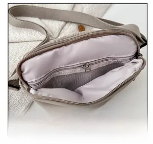 Detail view of the nylon crossbody bag interior with zipper pocket and mesh compartment
