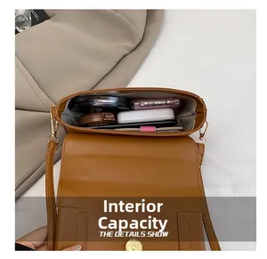 Macro view of the spacious inner compartment of the brown PU leather handbag with items