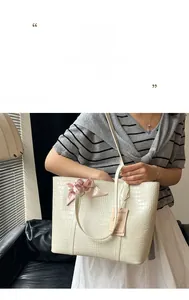 Détail du grand sac cabas blanc à motif crocodile avec un foulard floral rose attaché