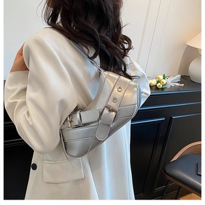Silver Y2K baguette bag with metallic texture and buckle detail on a female model