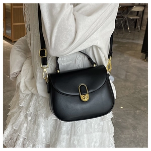 Detail of vintage black semi-circular crossbody bag featuring a golden oval twist lock