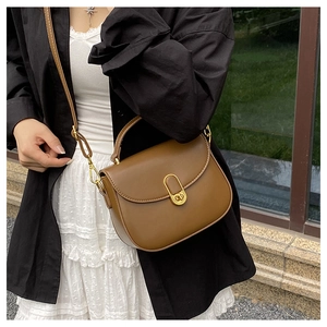 Brown leather moon bag with gold clasp shown on model for elegant styling