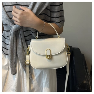 Close-up of creamy white crossbody bag with elegant gold twist lock and fine stitching