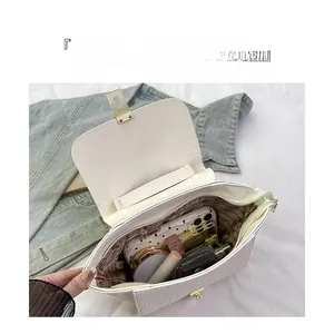 Detail view of large capacity white crocodile embossed bag with partitioned interior storage