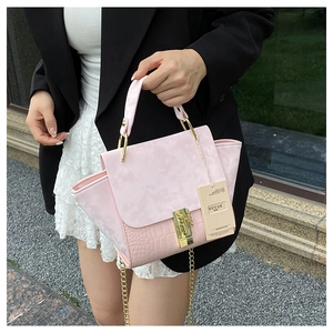 Detail of pink faux crocodile leather stitching and gold chain strap on handbag