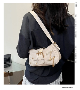 Detail of star-studded rivet underarm bag with gold star charms and metallic buckle accents