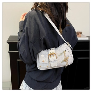 Detail of silver Y2K shoulder bag with star charm, metal rivets and textured leather