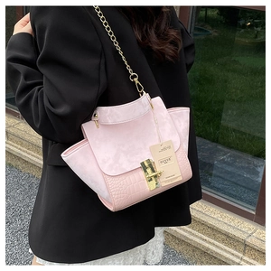 Detail of pink crocodile embossed leather with matte texture and gold square lock