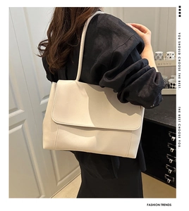 Creamy white PU leather tote bag with flap closure shown on shoulder for daily commute